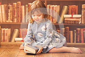 Adorable little bookworm girl reading books