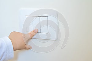 Adorable little boy child turning on the white light-switch with his finger