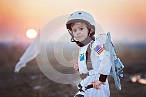 Adorable little boy, dressed as astronaut, playing in the park w