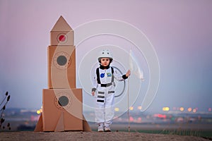 Adorable little boy, dressed as astronaut, playing in the park w