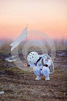 Adorable little boy, dressed as astronaut, playing in the park w