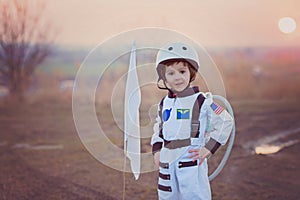 Adorable little boy, dressed as astronaut, playing in the park w
