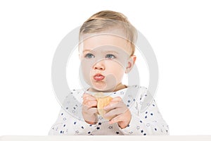 adorable little boy eating cookies and sitting in highchair