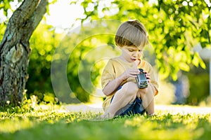Adorable little boy having fun outdoors on sunny summer day. Kid running outdoors. Child exploring nature. Summer activities for