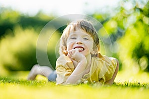 Adorable little boy having fun outdoors on sunny summer day. Kid running outdoors. Child exploring nature. Summer activities for