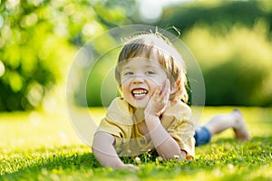 Adorable little boy having fun outdoors on sunny summer day. Kid running outdoors. Child exploring nature. Summer activities for