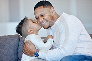 Adorable little boy kissing his dad on the cheek. African american man laughing with his eyes closed while receiving