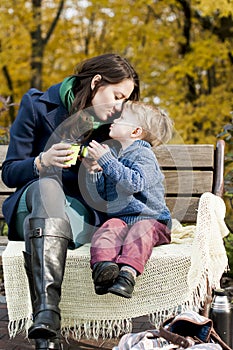 Adorable little boy reaches for his mother`s kiss