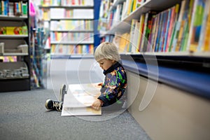 Adorable little boy, sitting in a book store