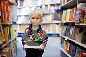 Adorable little boy, sitting in a book store