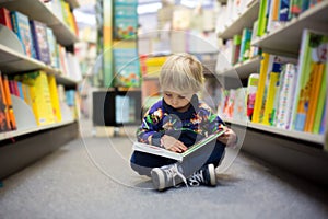 Adorable little boy, sitting in a book store