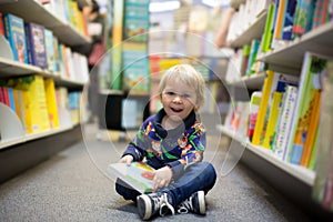 Adorable little boy, sitting in a book store