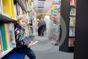 Adorable little boy, sitting in a book store