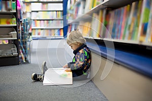 Adorable little boy, sitting in a book store