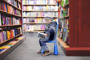 Adorable little boy, sitting in a book store