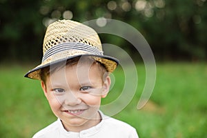Adorable little boy in summer hat. Headshot of a cute little preschool boy in summer hat smiling happily at camera