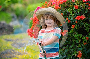 Adorable little boy is watering the plant outside the house, concept of plant growing learning activity for kid and