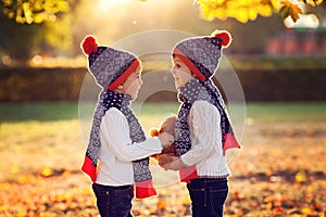 Adorable little brothers with teddy bear in park on autumn day