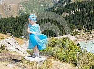 Adorable little child girl on grass on meadow. Summer green nature .