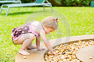 Adorable little child girl on grass. Summer green nature background.