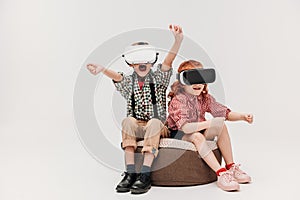 adorable little children playing in virtual reality headsets