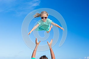 Adorable little daughter and her happy father having fun outdoor