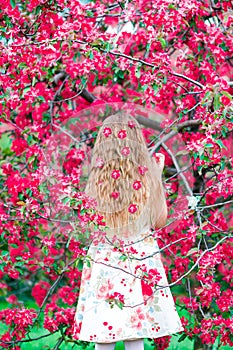 Adorable little girl in blooming apple tree garden on spring day