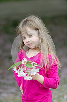 Adorable little girl in blooming cherry garden