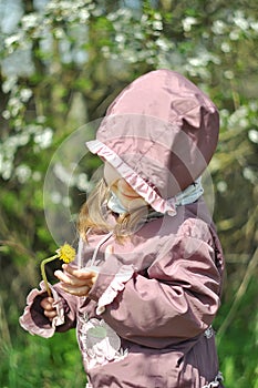 Adorable little girl in blooming cherry garden on beautiful spring day