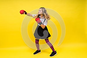 An adorable little girl boxer practicing punches in studio