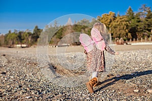 Adorable little girl with butterfly wings running