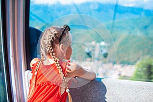 Adorable little girl in the cabin on the cable car