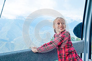 Adorable little girl in the cabin on the cable car