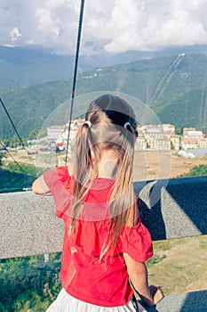 Adorable little girl in the cabin on the cable car