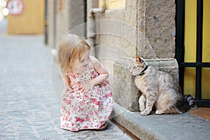 Adorable little girl and a cat outdoors