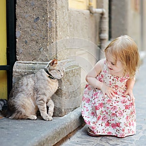 Adorable little girl and a cat outdoors