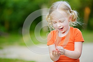 Adorable little girl catching little babyfrogs