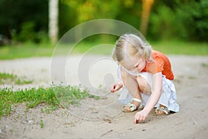 Adorable little girl catching little babyfrogs
