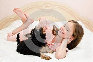 Adorable little girl child holding and playing with puppy yorkshire terrier