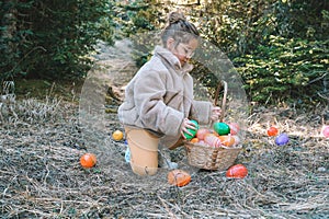 Adorable little girl collecting Easter eggs