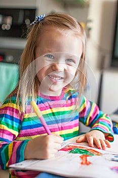 Adorable little girl draws paints sitting at the