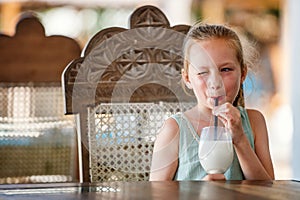 Adorable little girl drinking milkshake