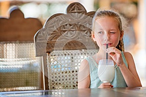 Adorable little girl drinking milkshake