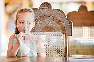 Adorable little girl drinking milkshake