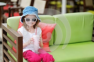 Adorable little girl drinking milkshake