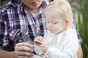 Adorable Little Girl Eating a Cookie with Daddy