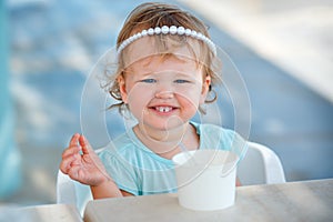 Adorable little girl eating ice cream at outdoor cafe