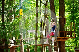 Adorable little girl enjoying her time in climbing adventure park