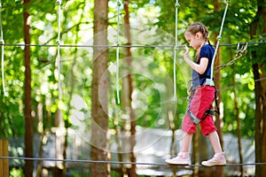 Adorable little girl enjoying her time in climbing adventure park