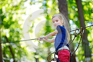 Adorable little girl enjoying her time in climbing adventure park